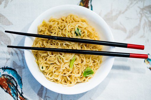 Chinese noodle dish with chopsticks on top
